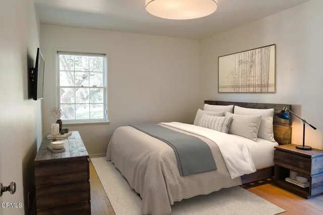 a bedroom with a bed and wooden floor