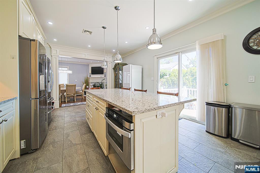 897 Virgil Avenue Ridgefield, NJ 07657 - Photo 31 of 50 a kitchen with stainless steel appliances granite countertop stove a refrigerator and a kitchen island with wooden floor