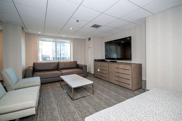 a projector room with couch chairs and flat screen tv