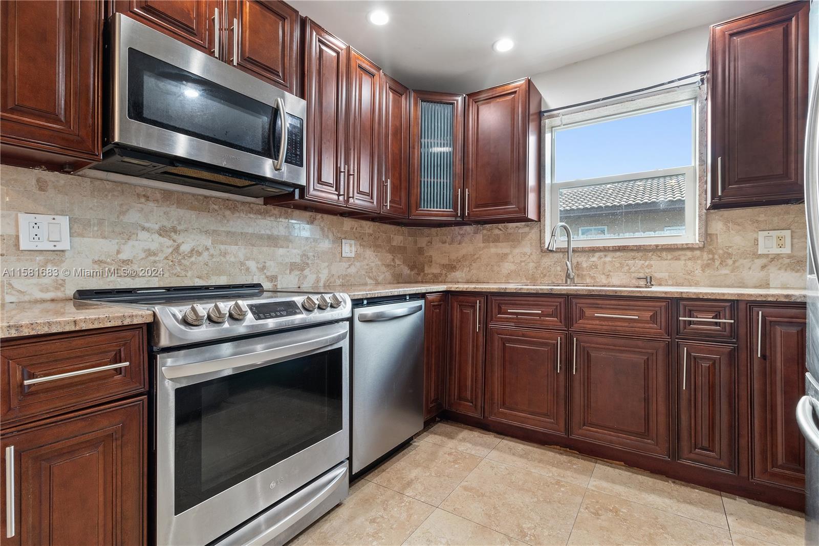 10680 Ember Street Boca Raton, FL 33428 - Photo 1 of 19 a kitchen with granite countertop wooden cabinets stainless steel appliances and a sink