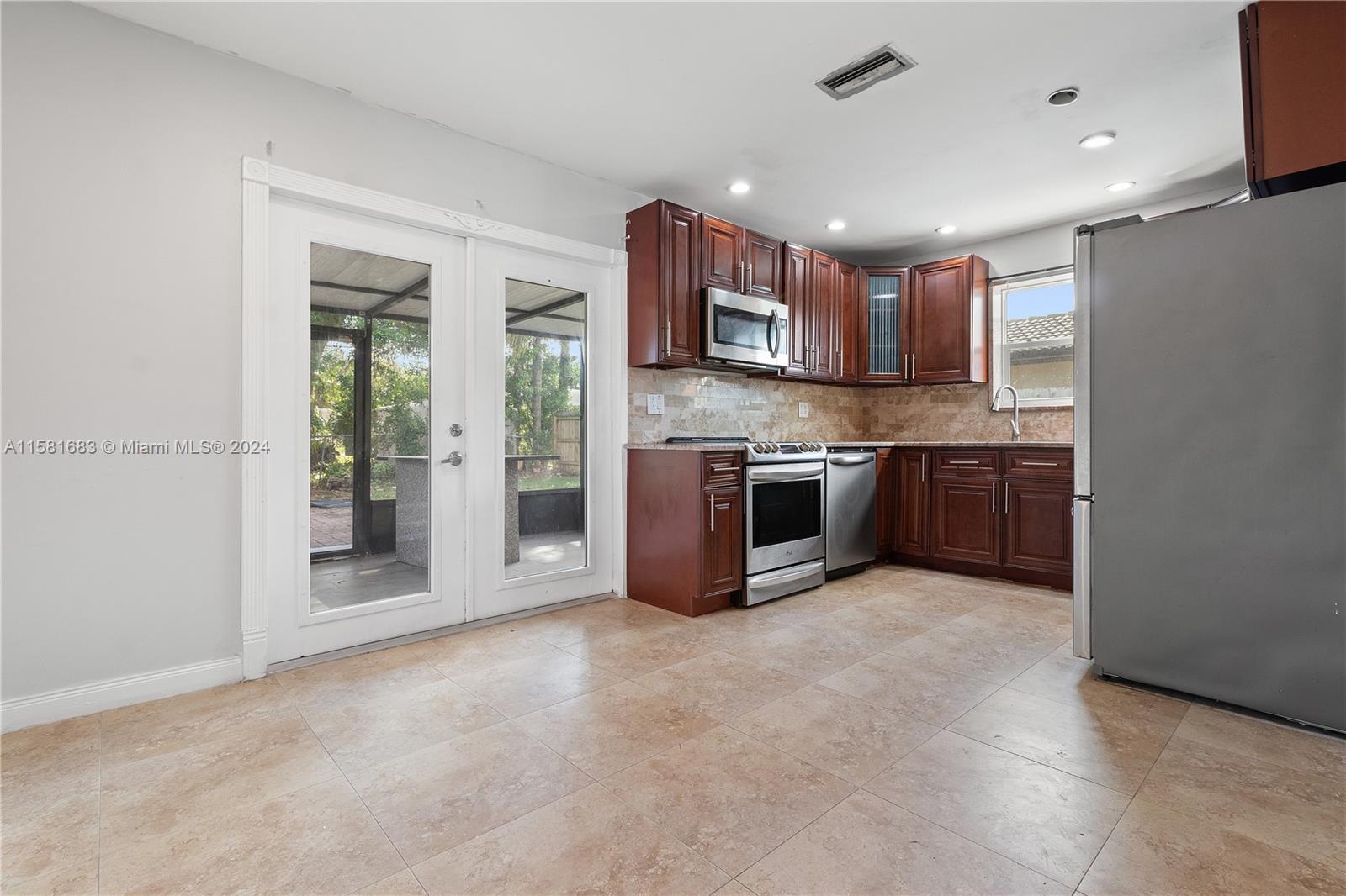10680 Ember Street Boca Raton, FL 33428 - Photo 2 of 19 a large kitchen with stainless steel appliances granite countertop a stove and a sink