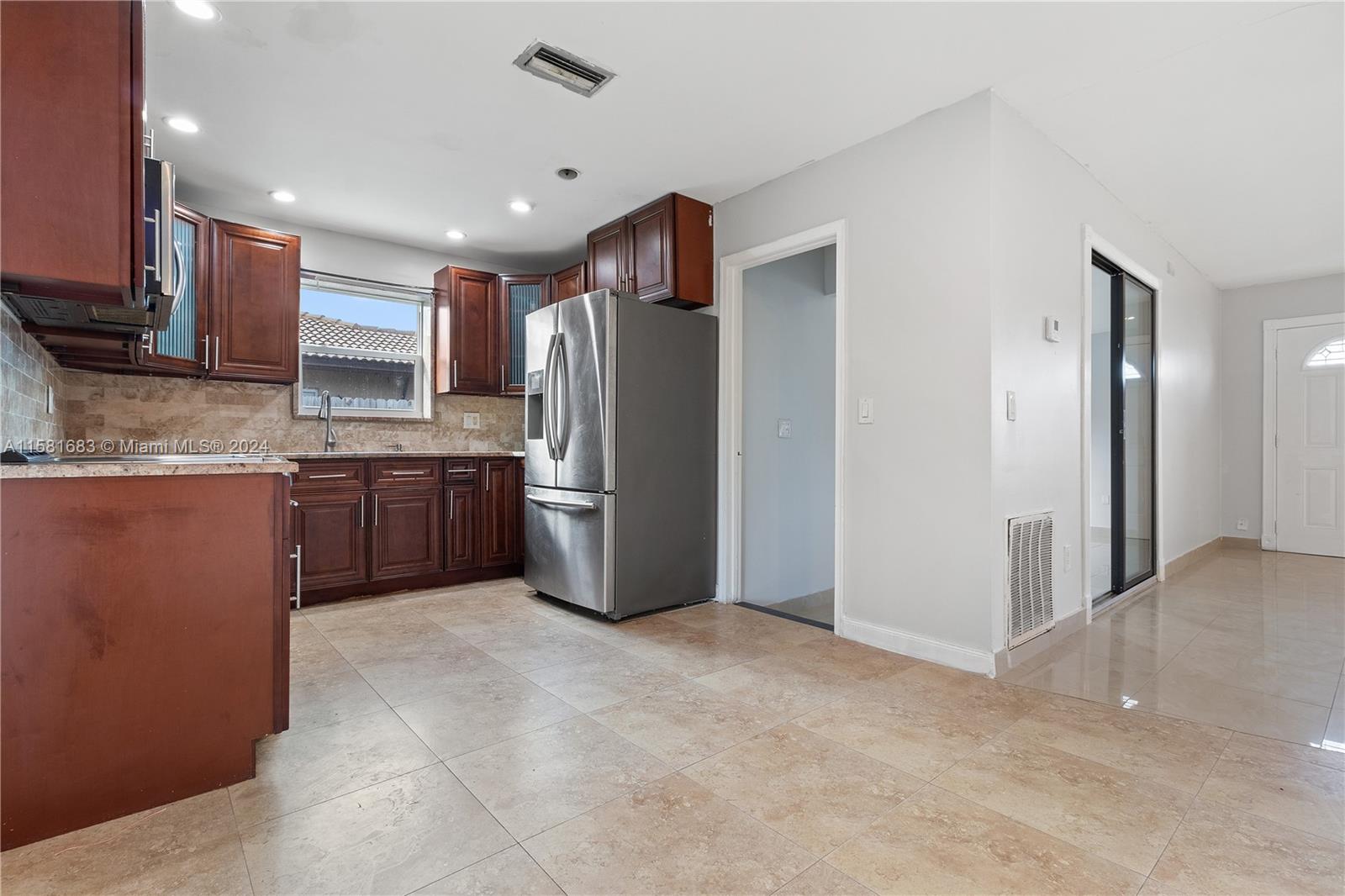 10680 Ember Street Boca Raton, FL 33428 - Photo 3 of 19 a kitchen with stainless steel appliances granite countertop a refrigerator and a sink