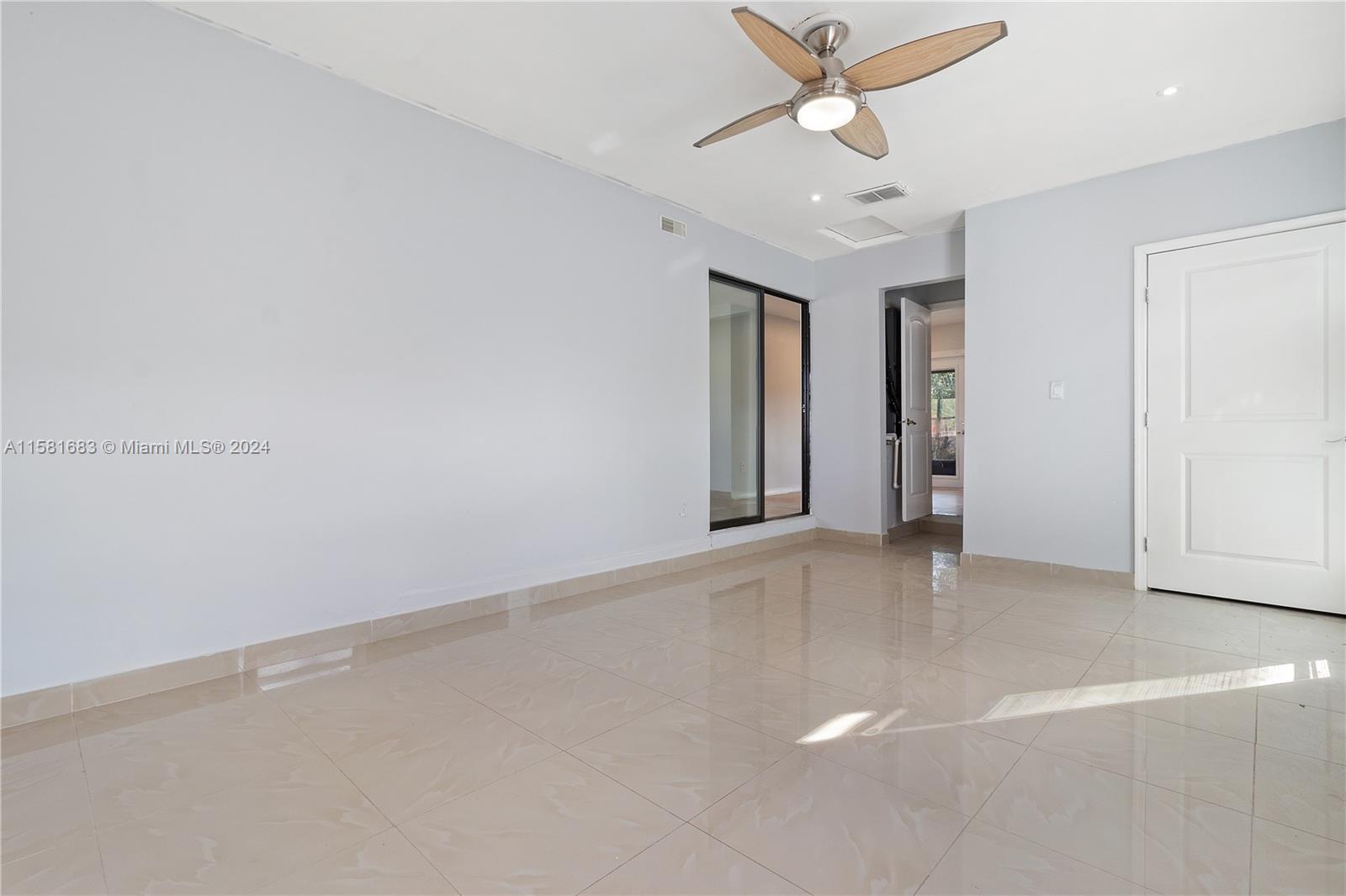 10680 Ember Street Boca Raton, FL 33428 - Photo 6 of 19 an empty room with a ceiling fan and a window
