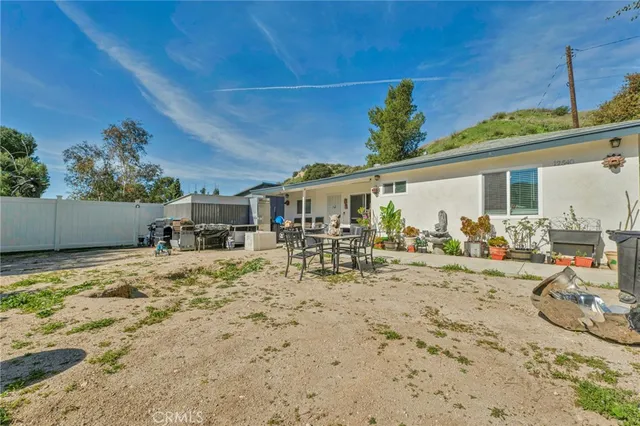 a view of a backyard with a table and chairs under an umbrella