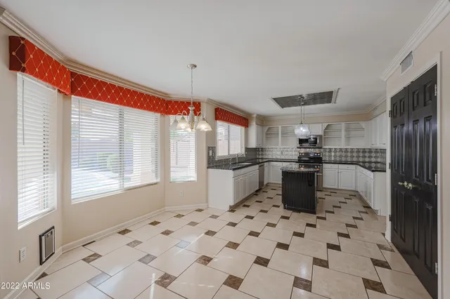 a kitchen with granite countertop a sink a counter space appliances and cabinets
