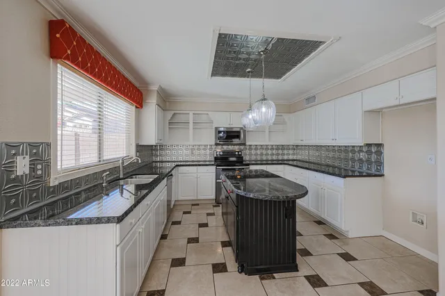 a kitchen with kitchen island granite countertop a sink cabinets and stainless steel appliances