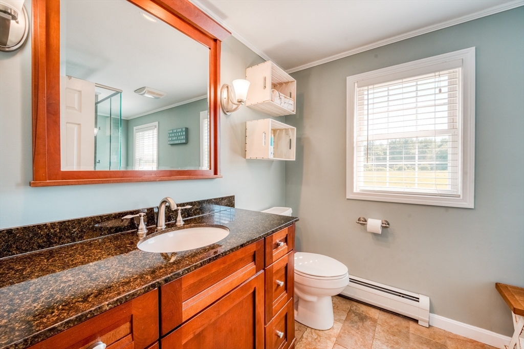 46 Brookline Street Pepperell, MA 01463 - Photo 23 of 41 a bathroom with a granite countertop sink toilet and mirror