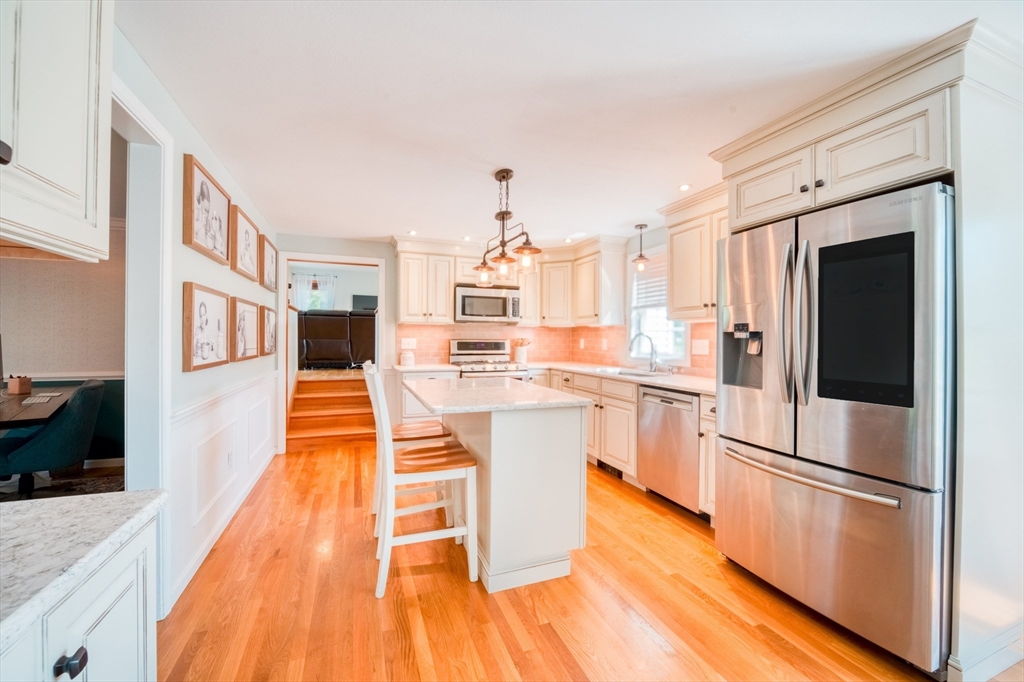 46 Brookline Street Pepperell, MA 01463 - Photo 9 of 41 a kitchen with stainless steel appliances granite countertop a refrigerator a stove top oven and white cabinets