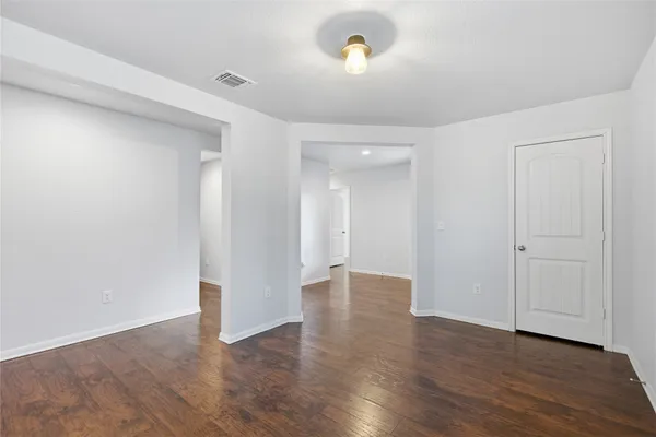 a view of an empty room with wooden floor