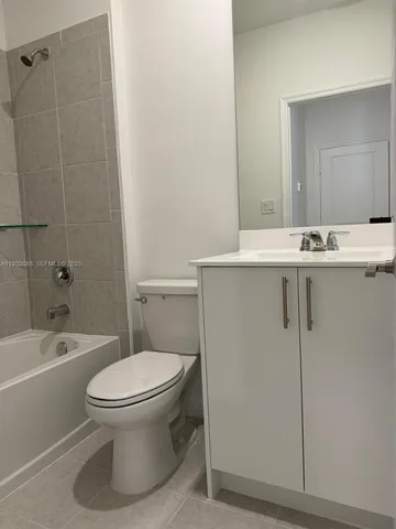 a white toilet and tub sitting next to a bathroom sink