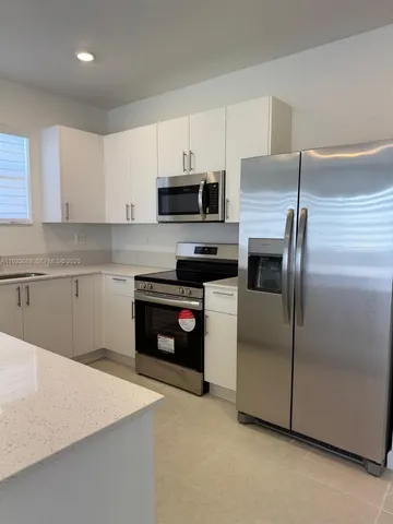 a view of a kitchen with white cabinets