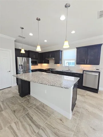 a kitchen with stainless steel appliances granite countertop a stove a refrigerator a sink and a oven