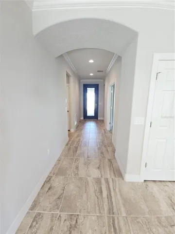 a view of a hallway with wooden floor and a bathroom