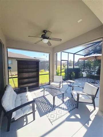 a living room with patio furniture and a large window