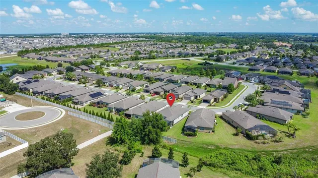 an aerial view of a residential houses with outdoor space and a lake view