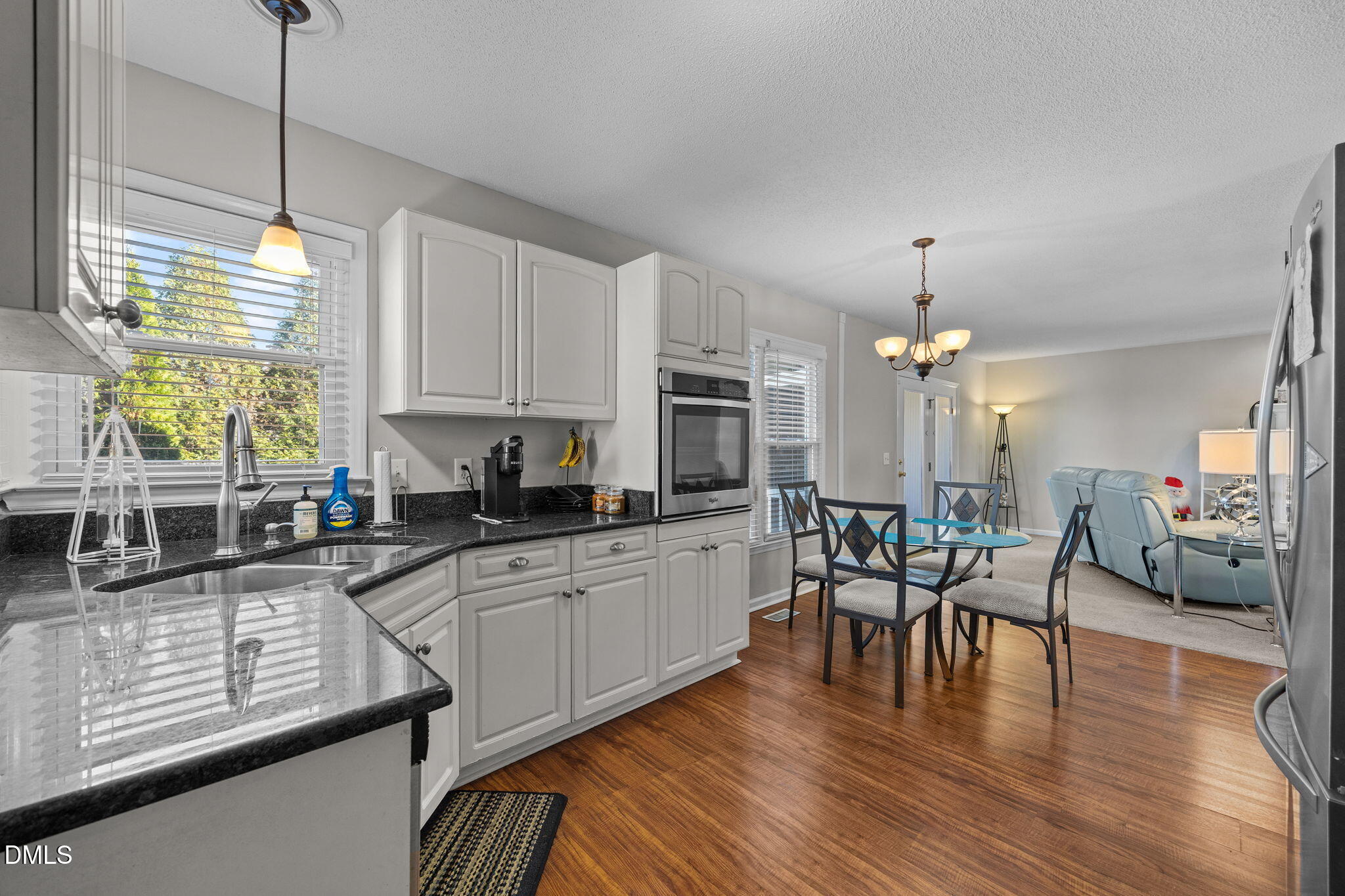 30 Stockton Drive Angier, NC 27501 - Photo 22 of 52 a kitchen with stainless steel appliances granite countertop a stove top oven a sink a dining table and chairs with wooden floor