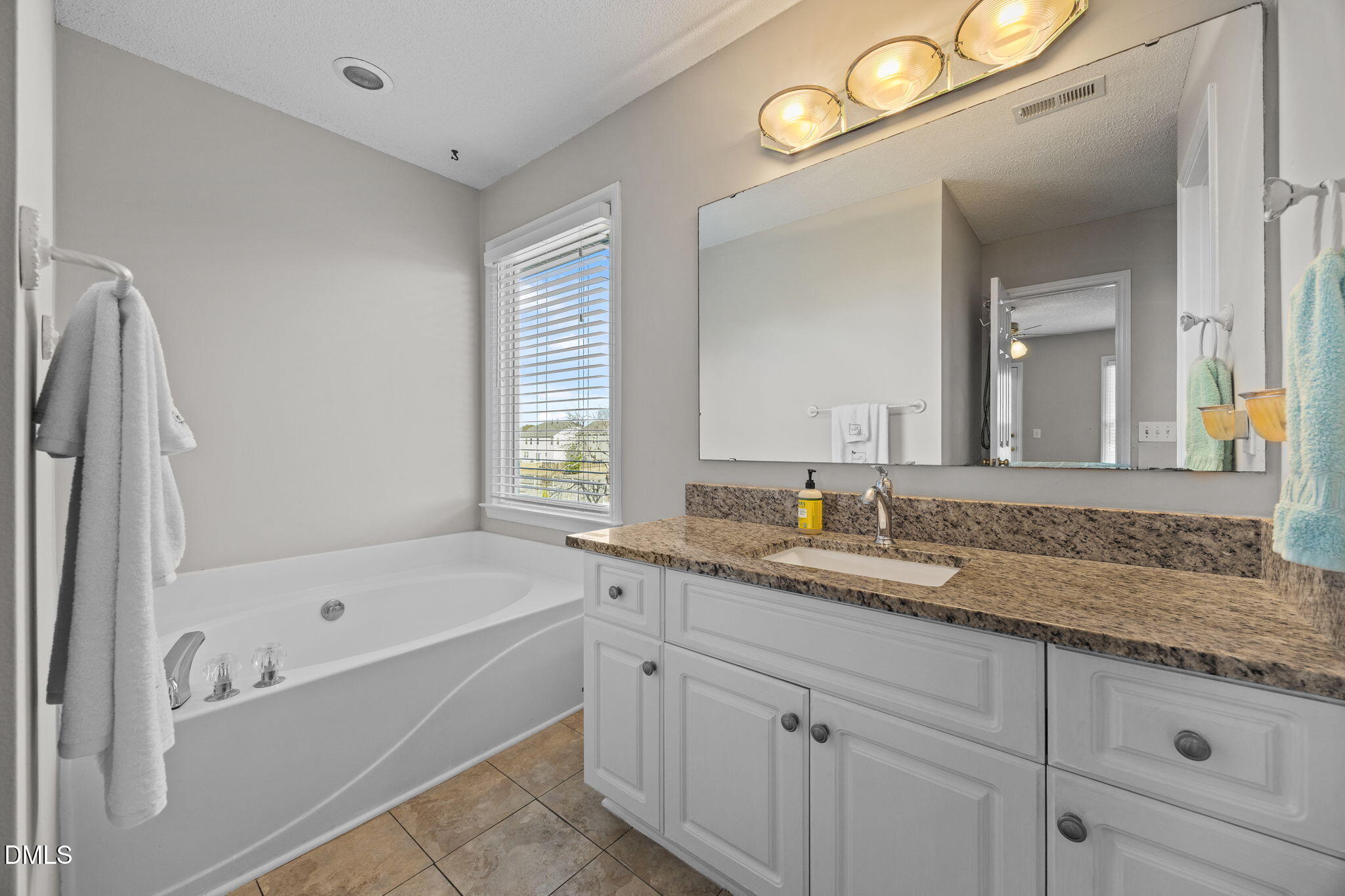 30 Stockton Drive Angier, NC 27501 - Photo 38 of 52 a bathroom with a granite countertop sink mirror bathtub and next to a window
