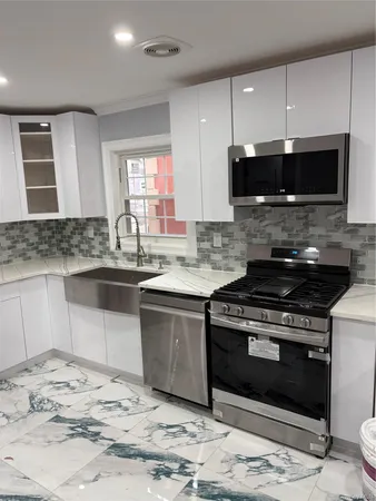 a kitchen with stainless steel appliances granite countertop a stove a sink and a microwave