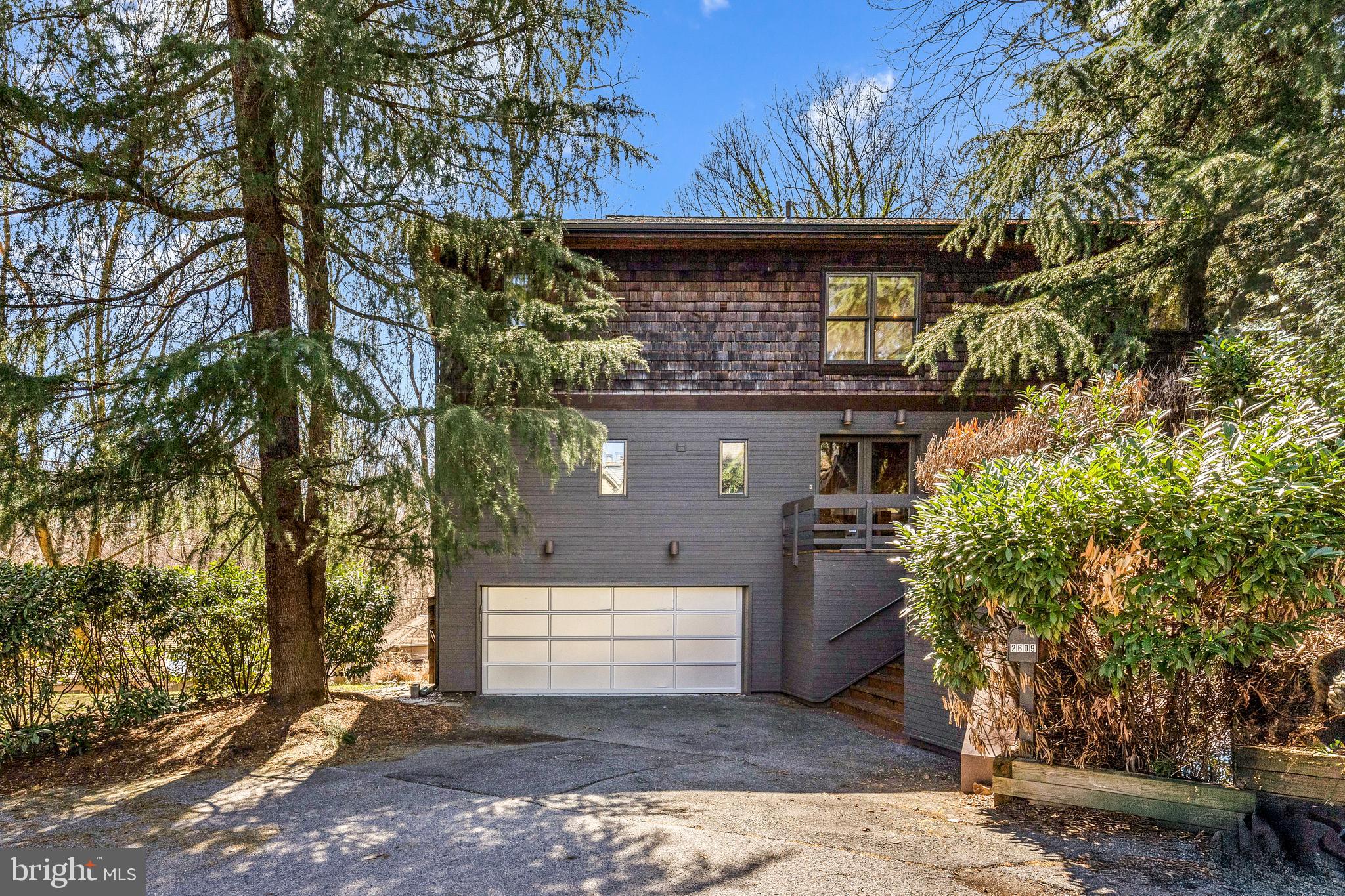 a front view of a house with a tree