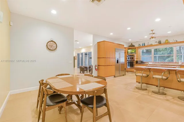 a kitchen with stainless steel appliances granite countertop a refrigerator a sink a stove and a microwave