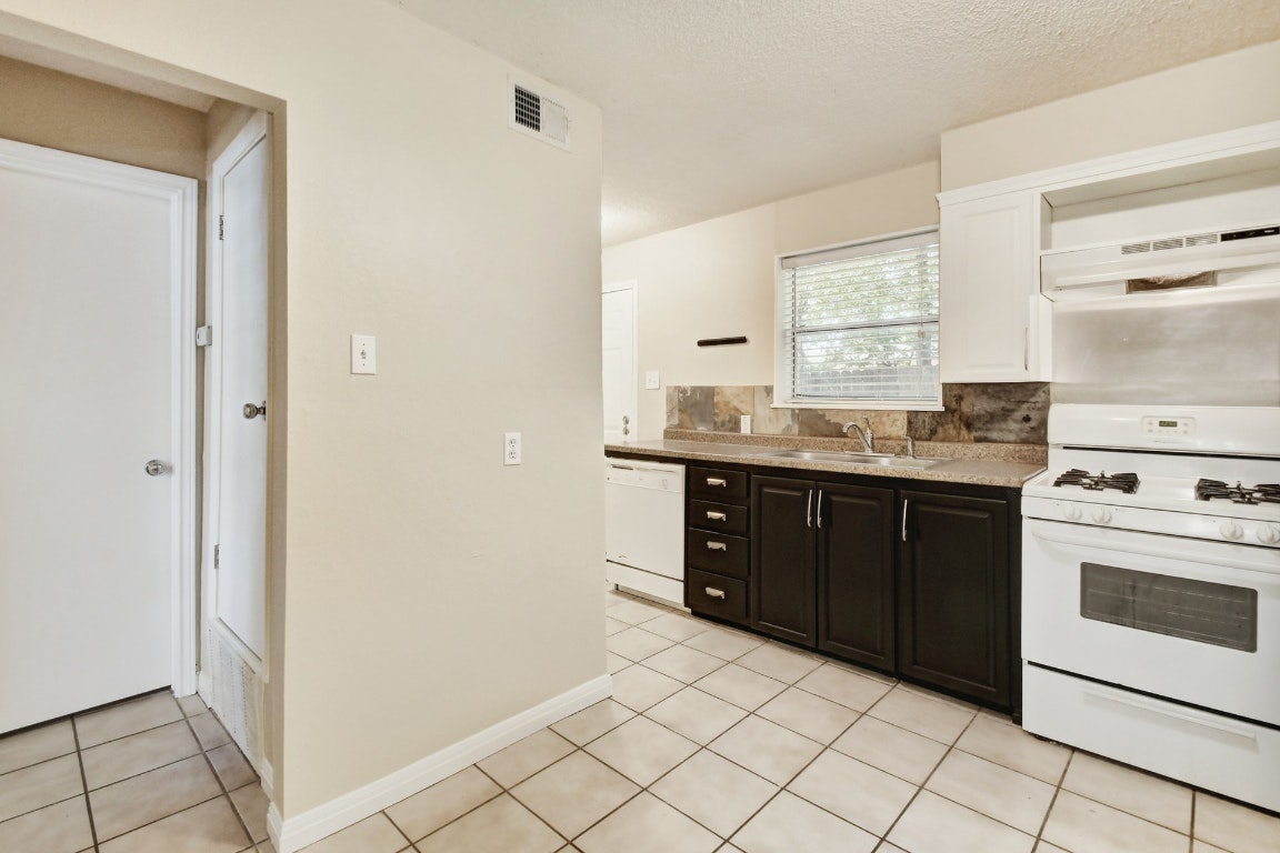 1704 East M. Franklin Avenue, Unit B Austin, TX 78721 - Photo 12 of 26 a kitchen with a sink stove and cabinets