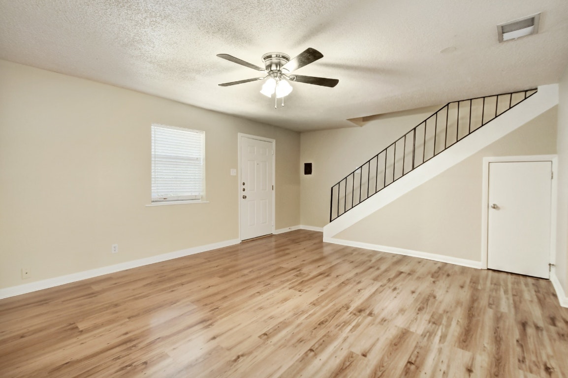 1704 East M. Franklin Avenue, Unit B Austin, TX 78721 - Photo 5 of 26 a view of an empty room with wooden floor and a chandelier fan