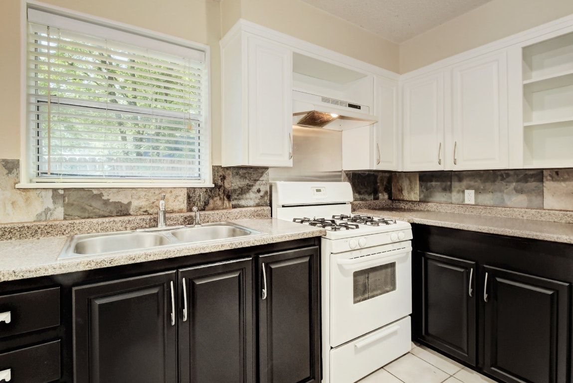 1704 East M. Franklin Avenue, Unit B Austin, TX 78721 - Photo 8 of 26 a kitchen with granite countertop white cabinets and white appliances