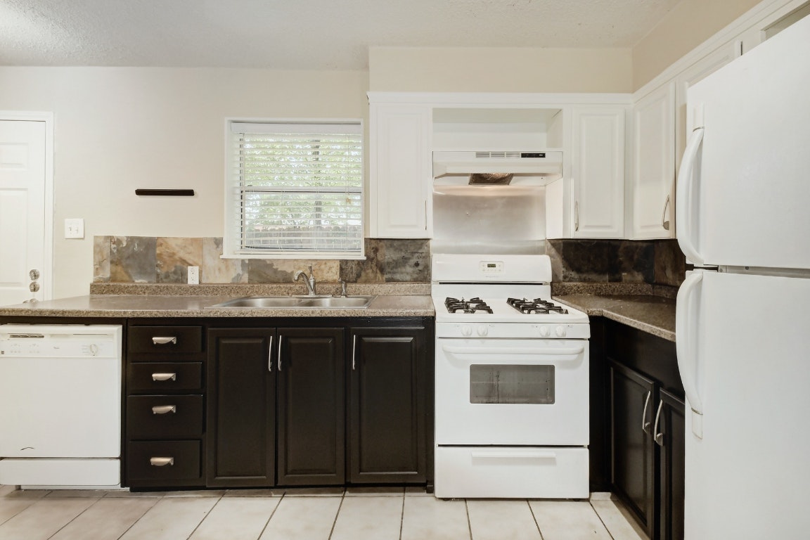 1704 East M. Franklin Avenue, Unit B Austin, TX 78721 - Photo 10 of 26 a kitchen with a stove white cabinetry and a sink