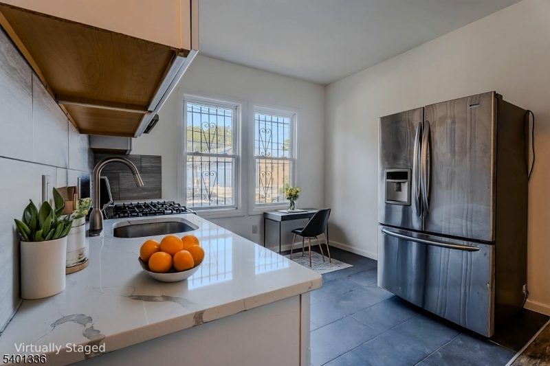 a kitchen with stainless steel appliances a dining table and chairs