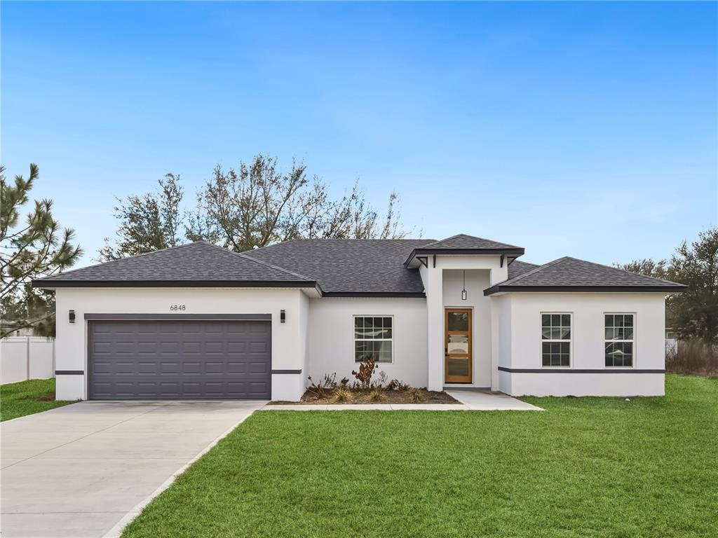 6848 Southwest 128th Place Ocala, FL 34473 - Photo 1 of 1 a front view of a house with a garden and yard