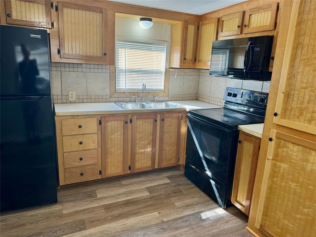 a kitchen with cabinets stainless steel appliances a sink and a window