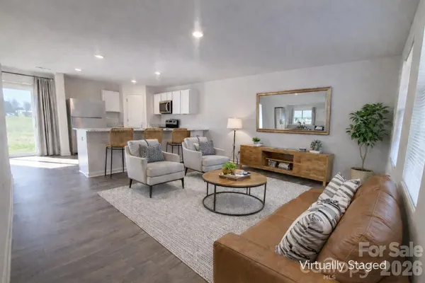 a living room with furniture and a dining table with wooden floor