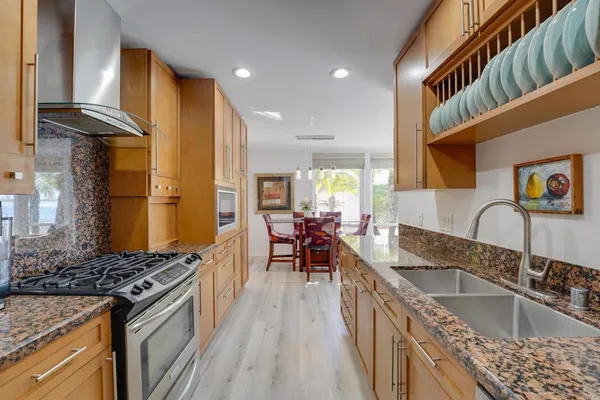 a kitchen with kitchen island granite countertop lots of counter top space and stainless steel appliances