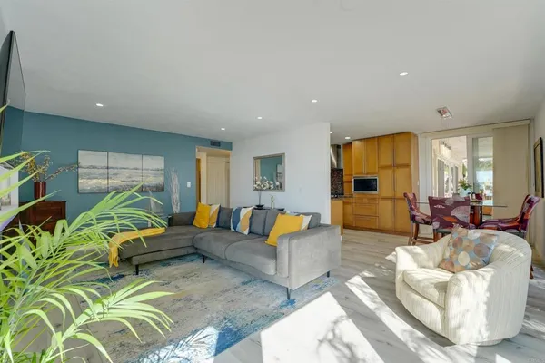 a living room with furniture or couch and a dining table with wooden floor