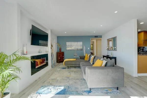 a living room with furniture a fireplace a flat screen tv and a window
