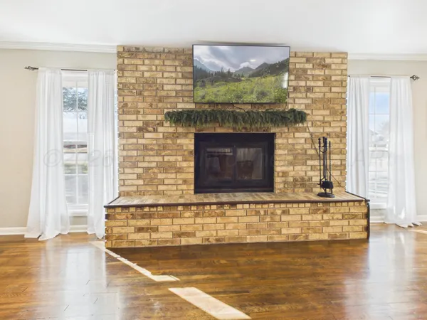 a view of a living room with a fireplace and windows