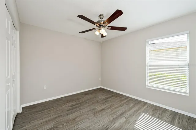 an a view of an empty room with wooden floor and a window