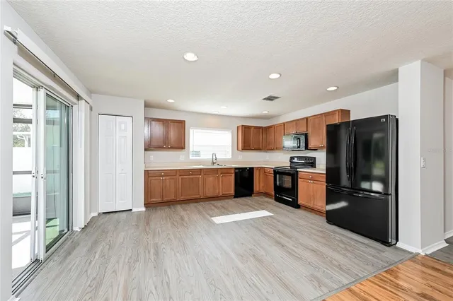 a large kitchen with stainless steel appliances wooden floors and wooden cabinets