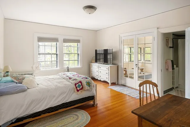 a bedroom with a bed a flat screen tv and dresser