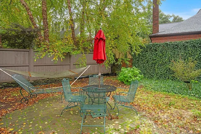 a view of a backyard with table and chairs and wooden fence