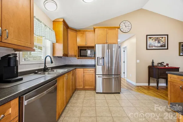 a kitchen with stainless steel appliances granite countertop a refrigerator and a sink
