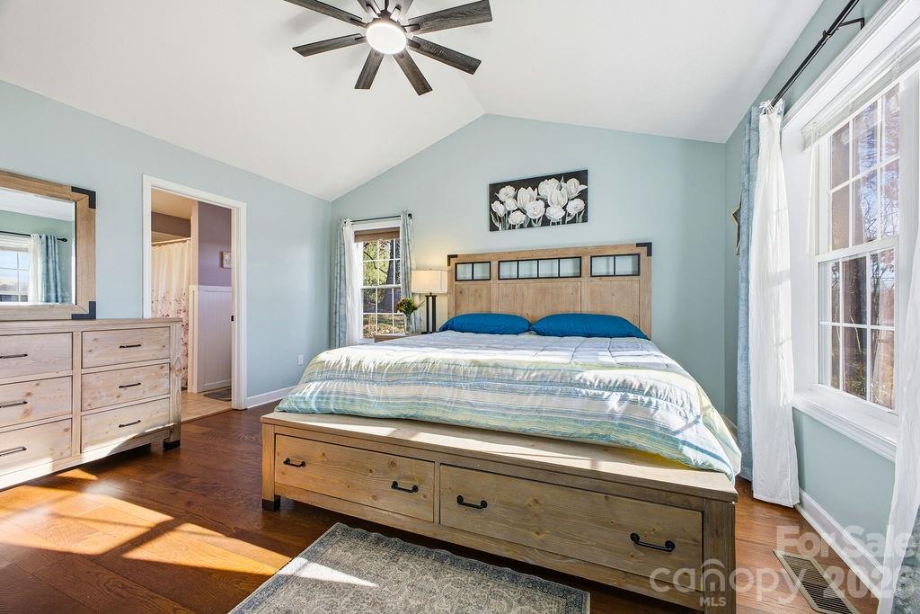 1113 Brookside Camp Road Hendersonville, NC 28792 - Photo 9 of 20 a bedroom with a bed and a chandelier