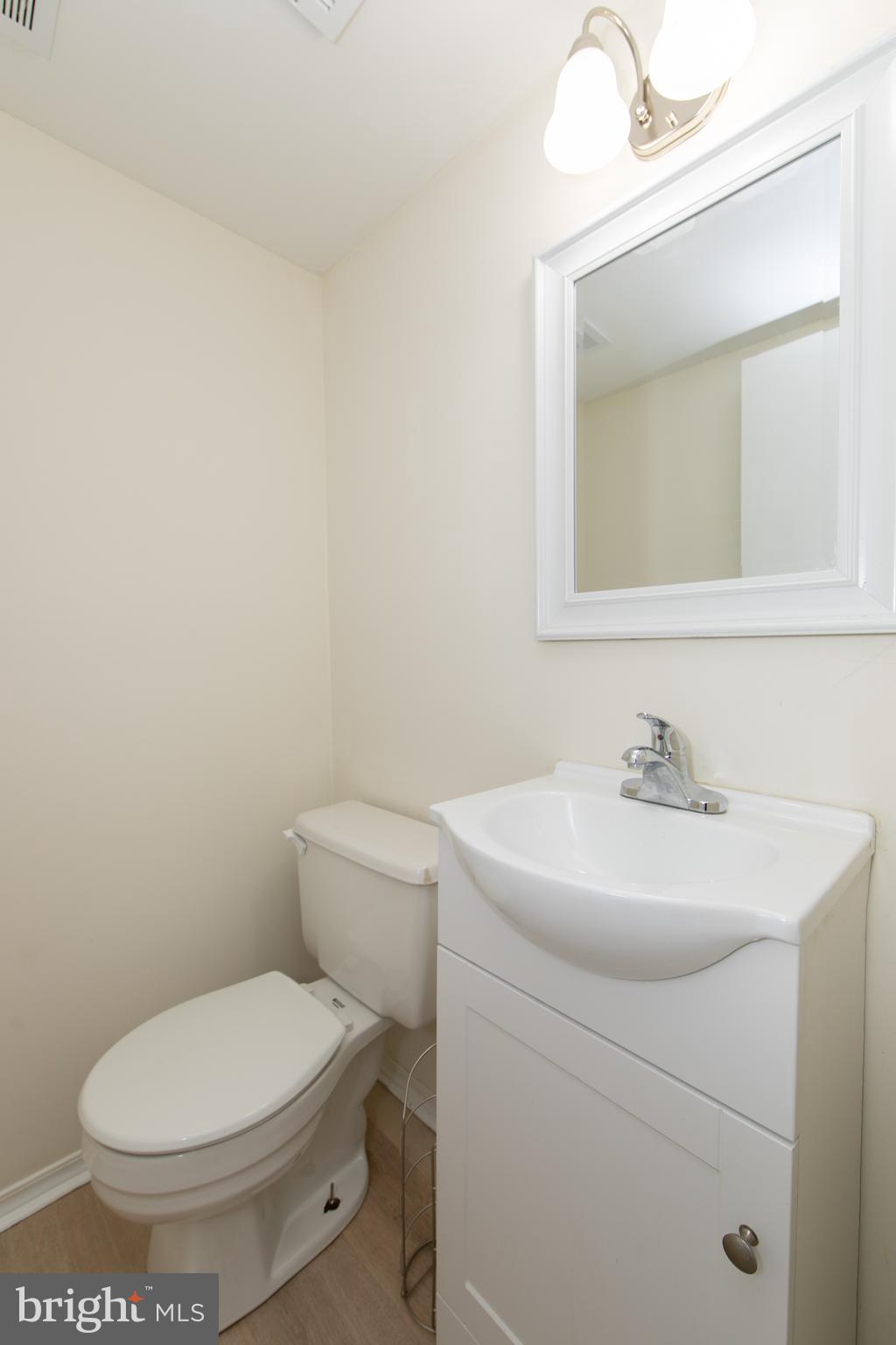 1042 Central Avenue Runnemede, NJ 08078 - Photo 16 of 36 a bathroom with a toilet a sink and mirror