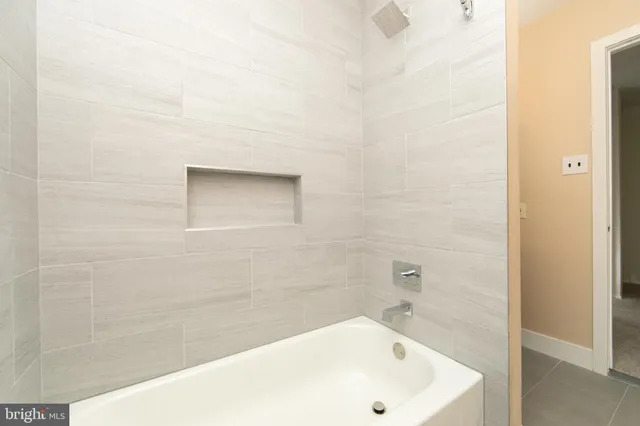 a bathroom with a white bath tub and a shower