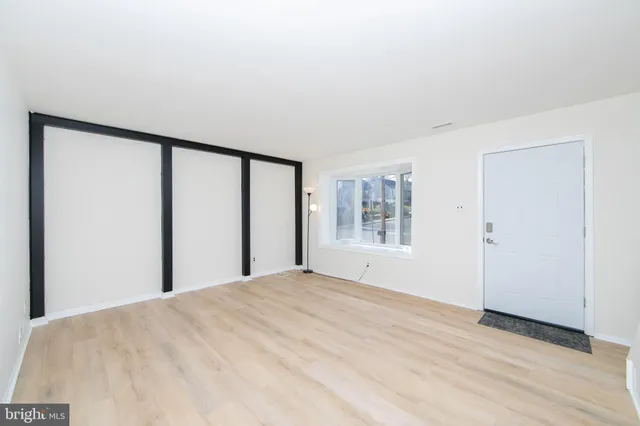 a view of a big room with wooden floor and windows