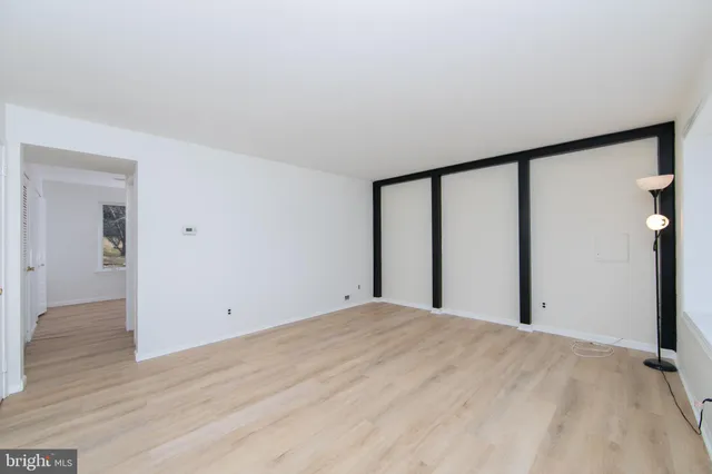 a view of a big room with wooden floor and windows