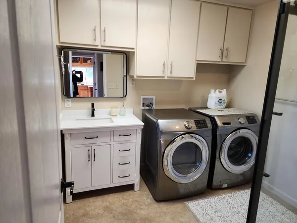 a utility room with sink dryer and washer
