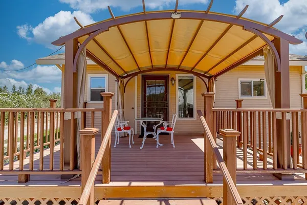 a view of a house with wooden deck and furniture