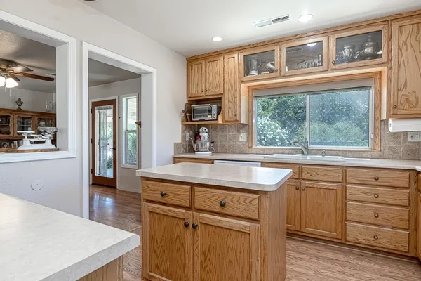 a kitchen with stainless steel appliances granite countertop a sink and cabinets with wooden floor