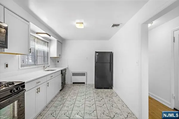 a kitchen with granite countertop a refrigerator and a stove